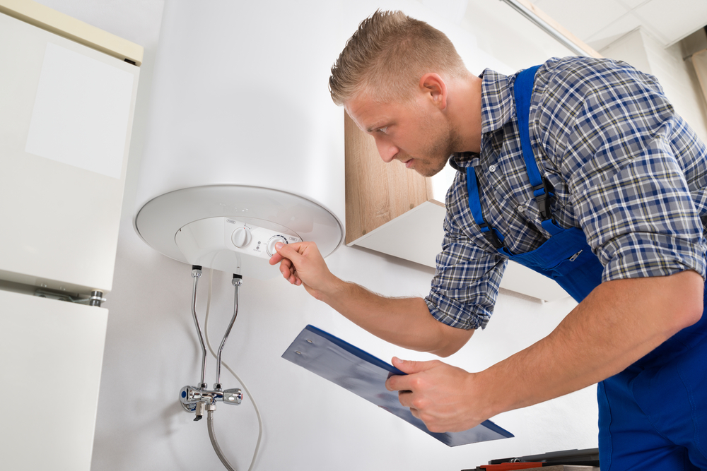 Male,Worker,With,Clipboard,Adjusting,Temperature,Of,Water,Heater