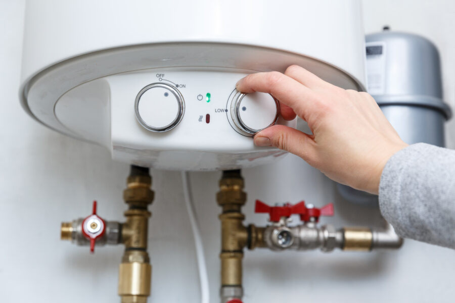 Female,Hand,Puts,Thermostat,Of,Electric,Water,Heater,(boiler),In